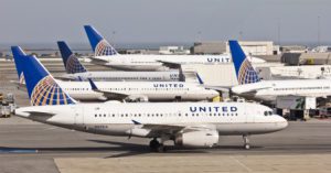 a group of airplanes parked at an airport