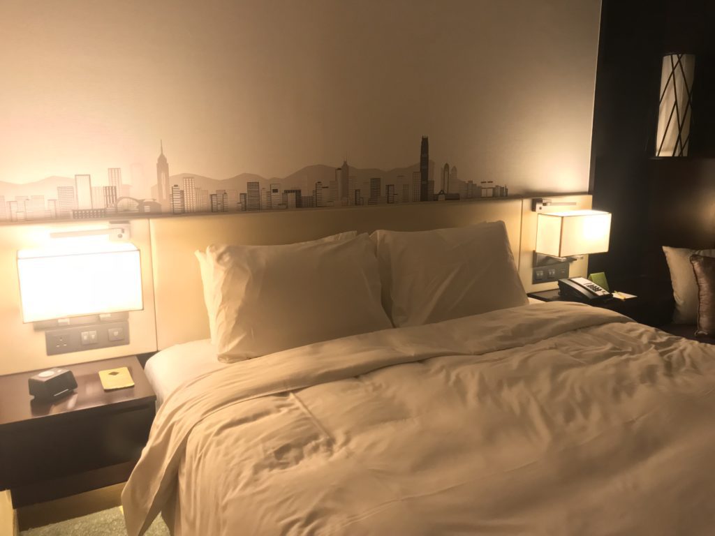 a bed with a white bedding and a lamp