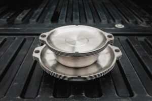 a stack of silver bowls on a black surface