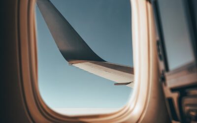 an airplane window with a view of the wing of an airplane