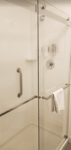 a glass shower door with a towel on the wall