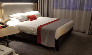 a bed with a red pillow