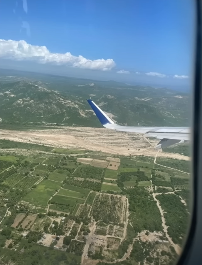 an airplane wing above a landscape