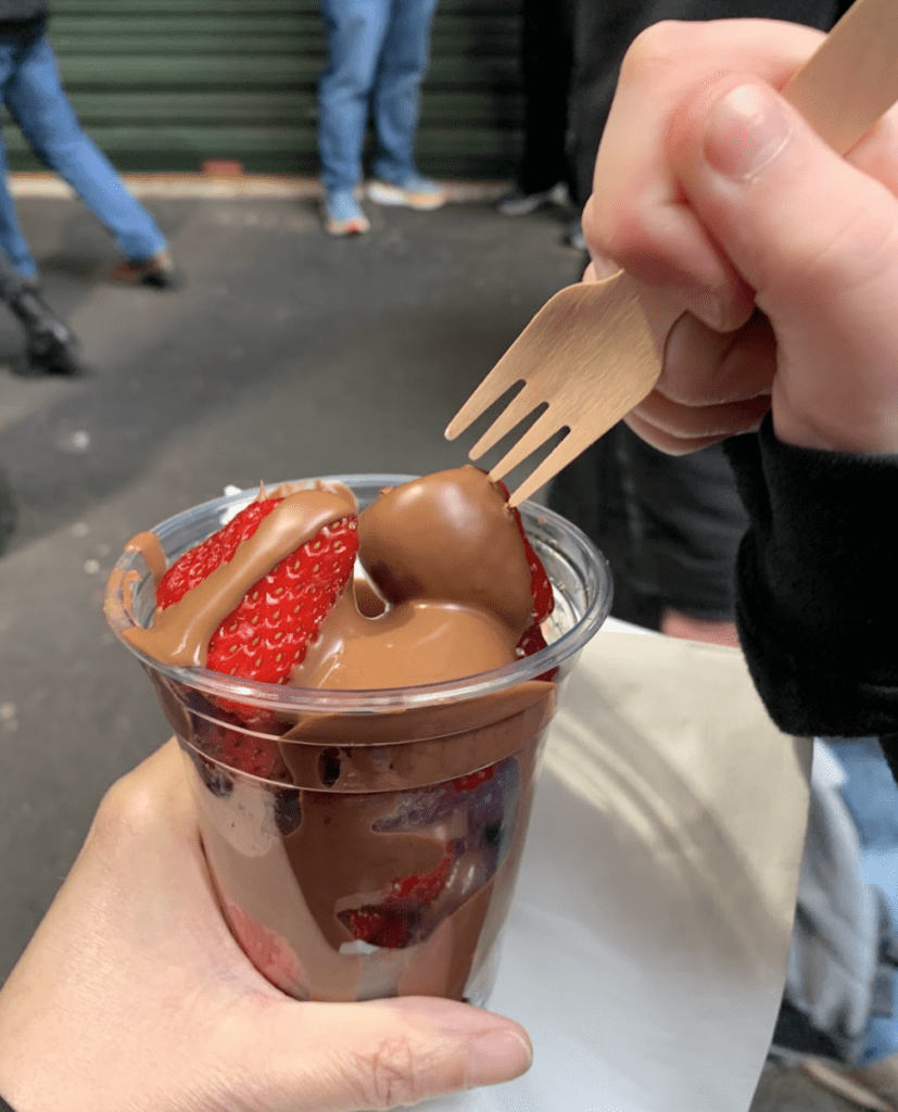 a person holding a fork over a chocolate dessert