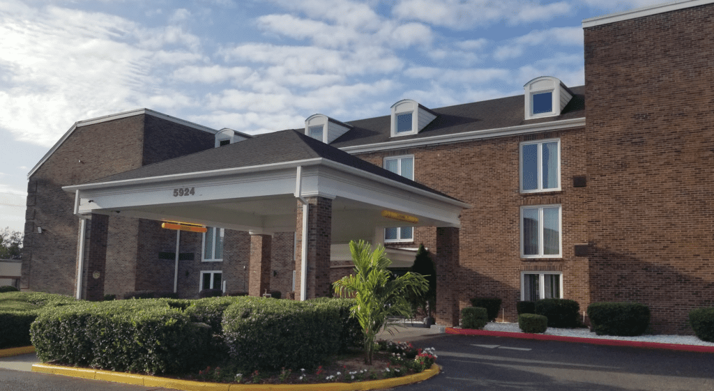 a building with a canopy and bushes