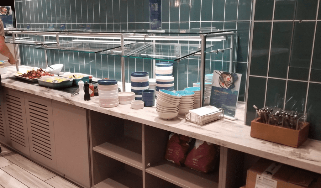 a counter with a glass shelf with plates and bowls on it