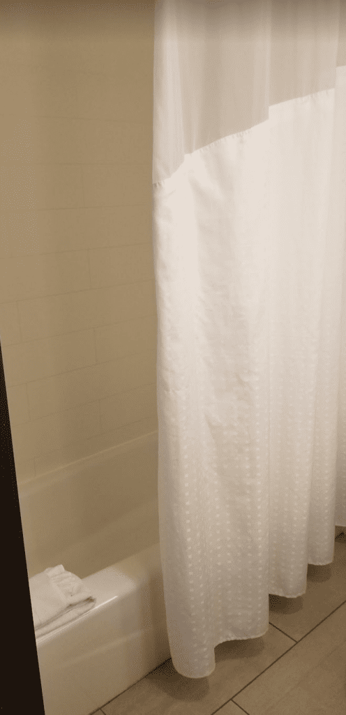 a white shower curtain in a bathroom