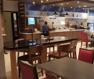 a man standing behind a counter in a restaurant