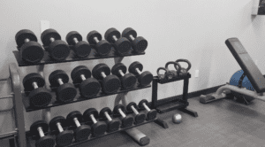 a rack of weights and kettlebells