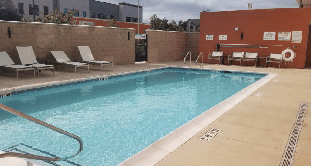 a pool with chairs and a brick wall