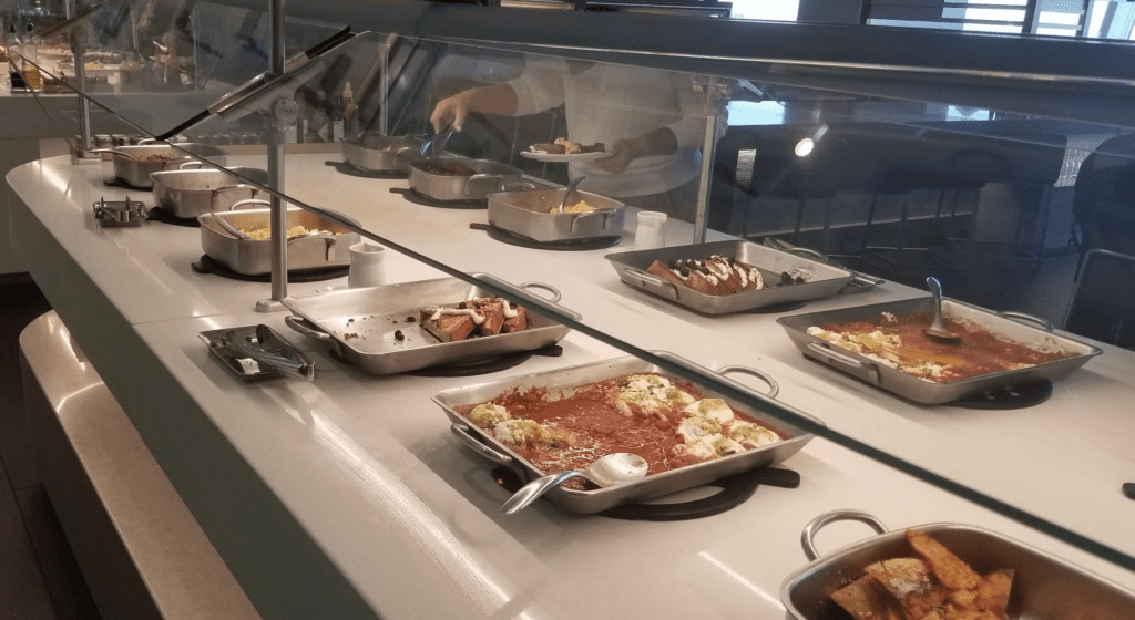 a person serving food in a buffet