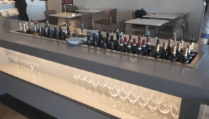 a row of wine glasses and bottles on a counter