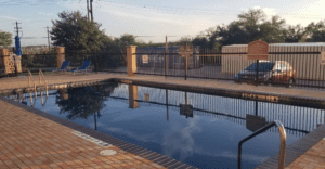 a pool with a fence and a car