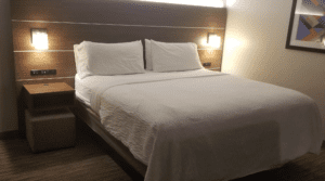 a bed with white sheets and pillows