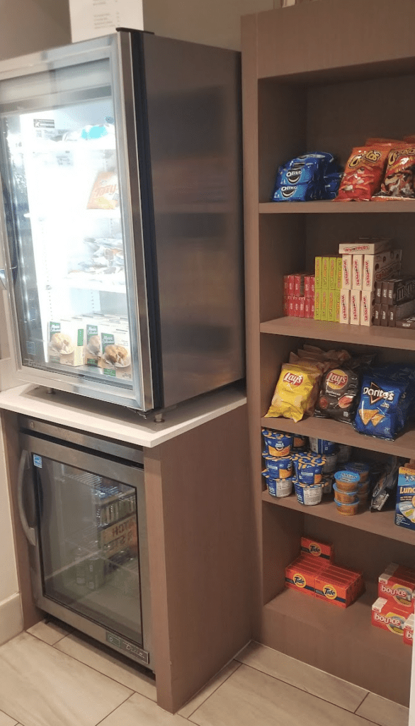 a refrigerator and shelves with snacks