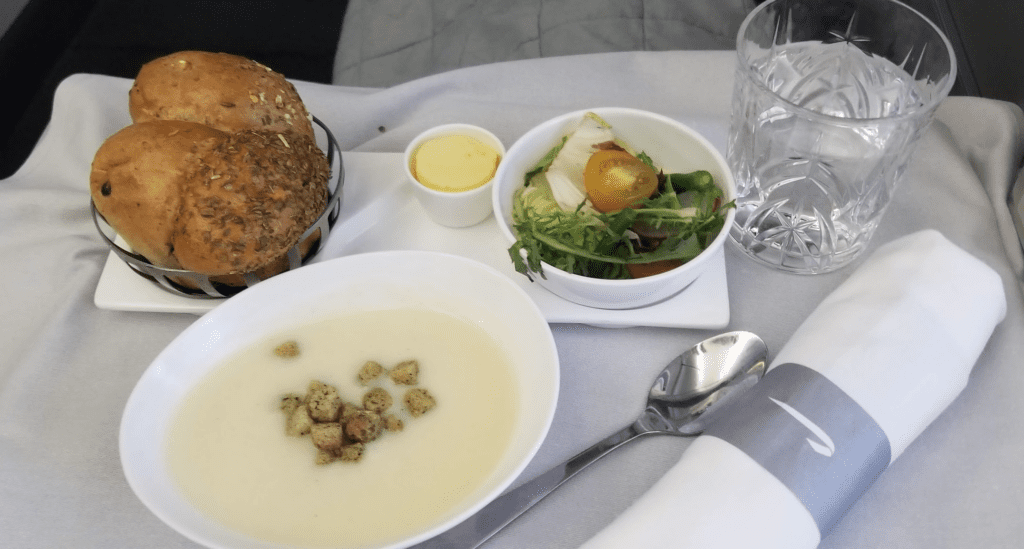 a bowl of soup and a salad on a tray