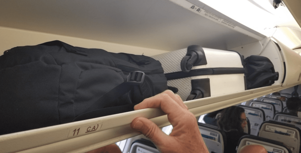 a hand holding a black bag on a shelf