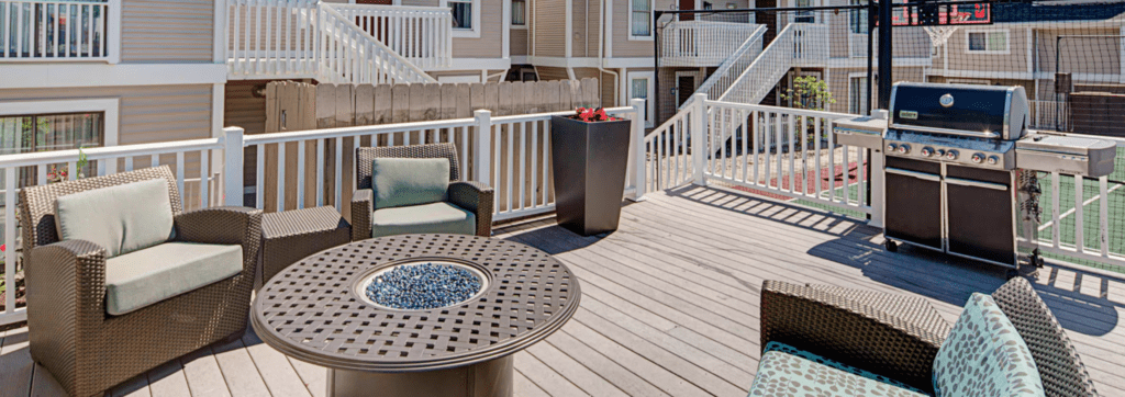 a patio with a fire pit and chairs